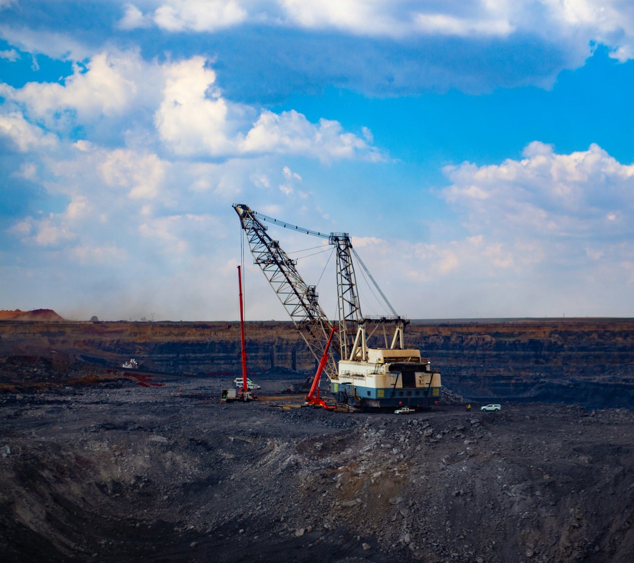 A large mining dragline in a South African open-pit mine beneath a blue sky.